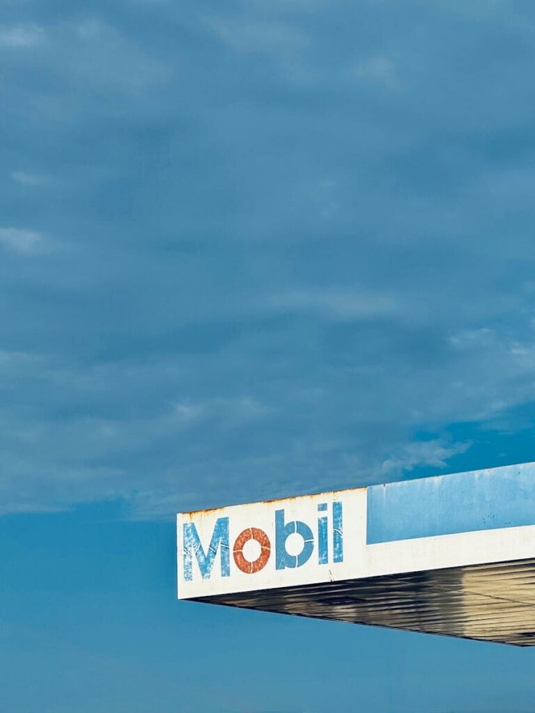 A Mobil gas station canopy photographed under a clear, blue sky.